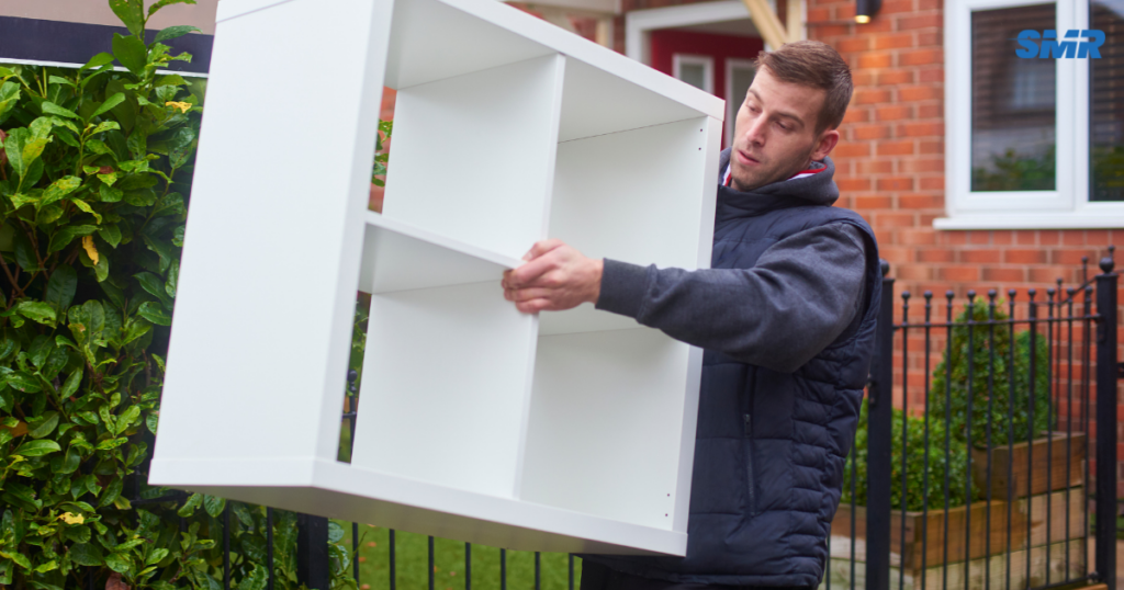 Two movers carrying a sofa for a small removals job in Thamesmead SE28