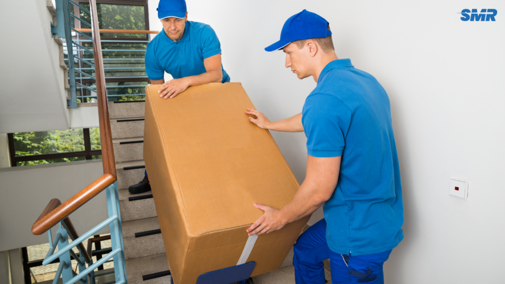 Movers carrying office furniture and equipment