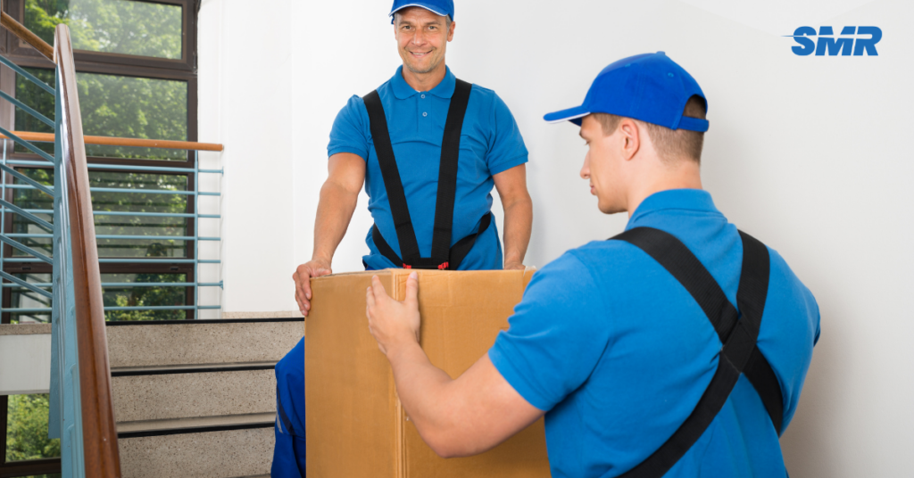 Movers handling office desks & boxes